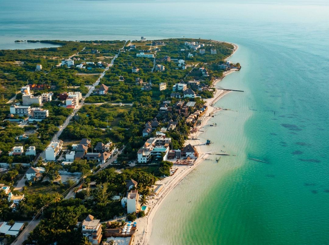 Playa de arena blanca en Holbox con aguas cristalinas y cielo azul